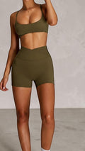 SOLID APPRL olive green athletic shorts with high-waisted crossover waistband, perfect for workouts.