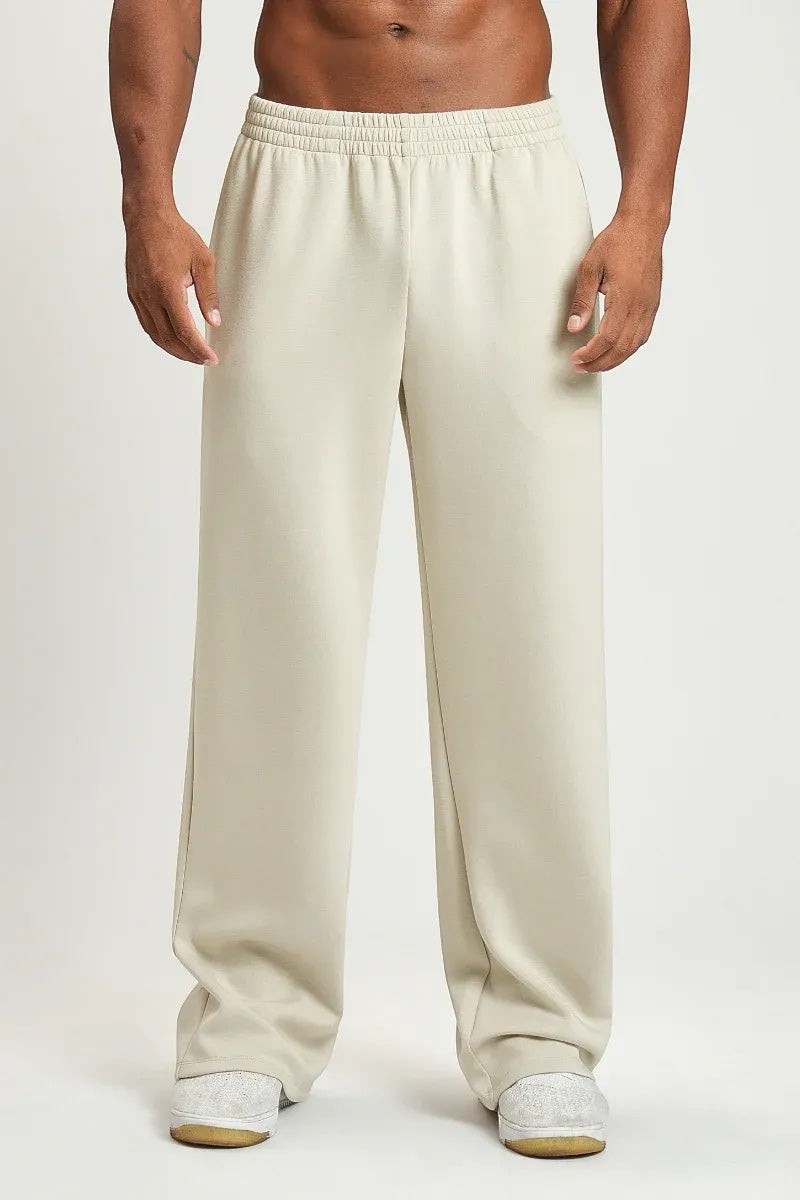 SOLID APPRL unisex relaxed fit lounge pants in beige with an elastic waistband, worn by a model on a white background.