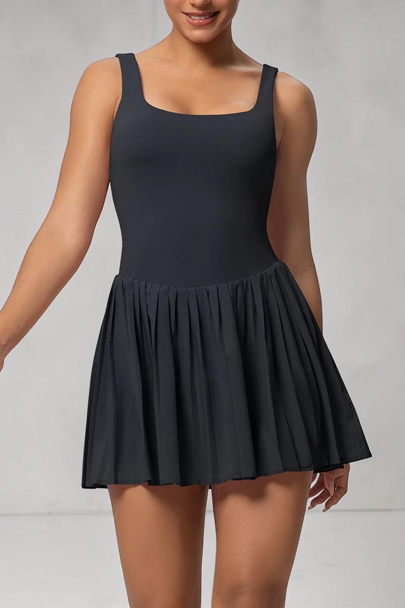 Model wearing a black SOLID APPRL moisture-wicking athletic tennis dress with a square neckline and pleated skirt.