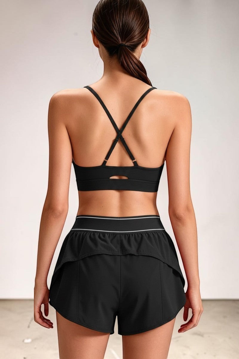 SOLID APPRL black athletic sports bra with criss-cross back and matching shorts with ruffled hem.