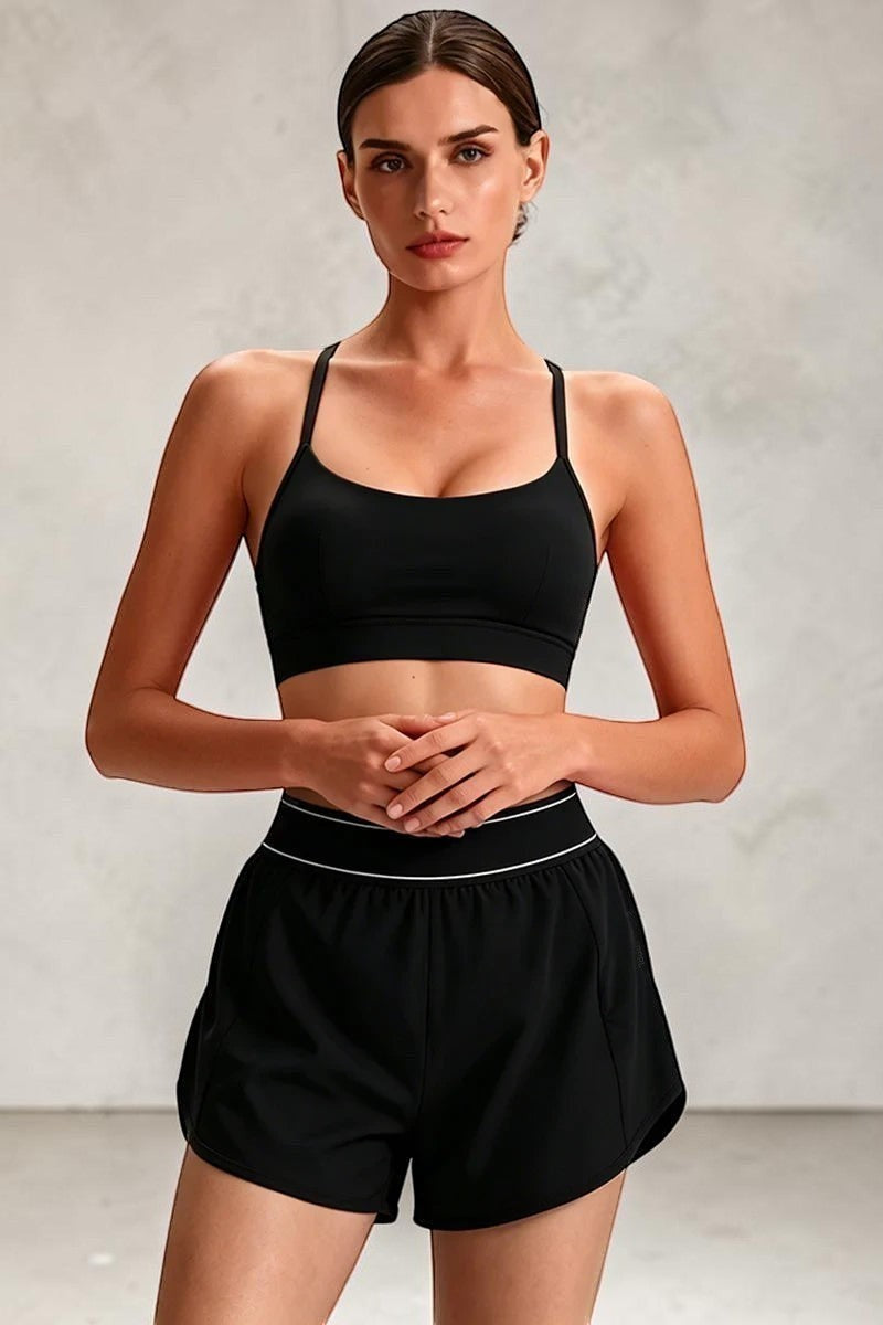 SOLID APPRL black athletic sports bra with criss-cross back and matching shorts with white trim. Breathable fabric.