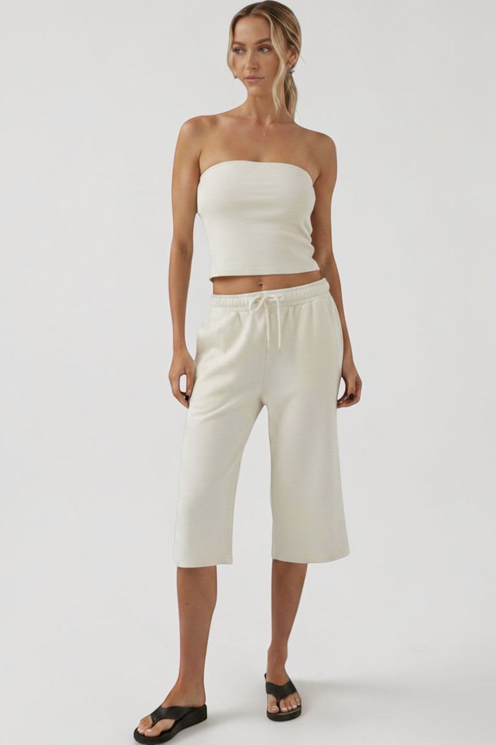 Model wearing a SOLID APPRL cream ribbed strapless tube top and matching wide-leg cropped lounge shorts.