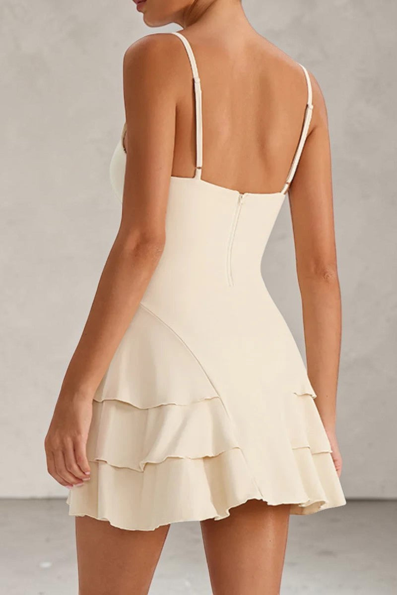 SOLID APPRL cream spaghetti strap mini dress with a tiered ruffle skirt and back zipper closure on a model.