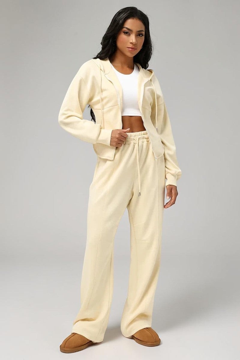 Model wearing a cream SOLID APPRL velour lounge set with a cropped zip-up hoodie and wide-leg drawstring pants.