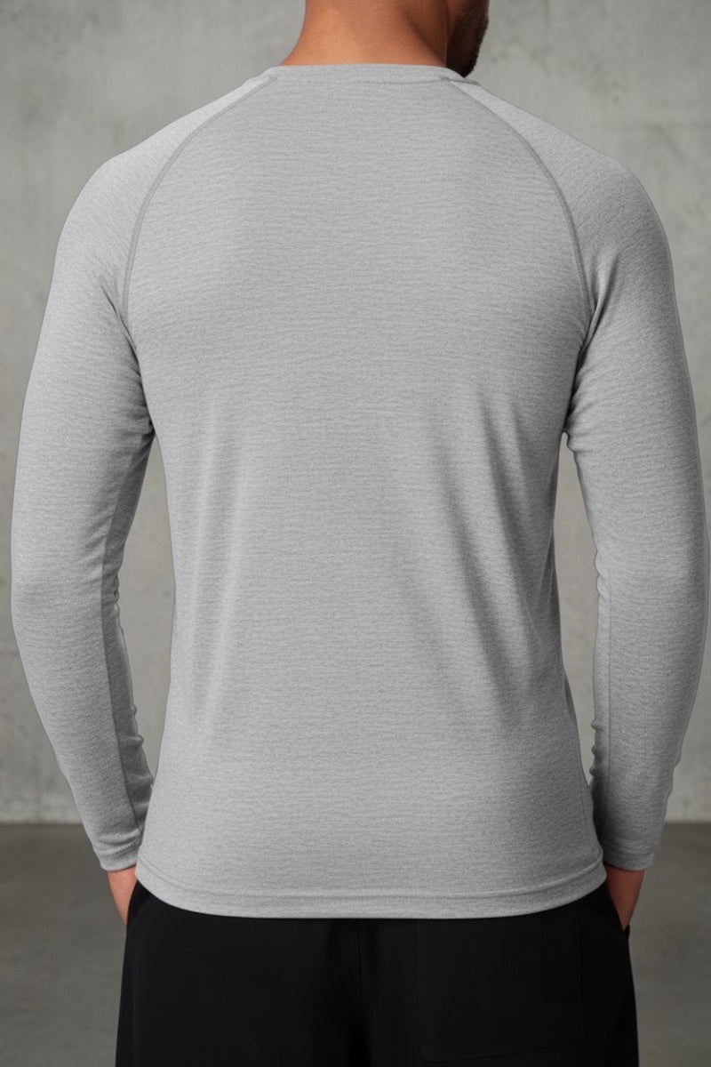Back view of a man wearing a SOLID APPRL dark green heathered long sleeve performance henley with raglan sleeves.