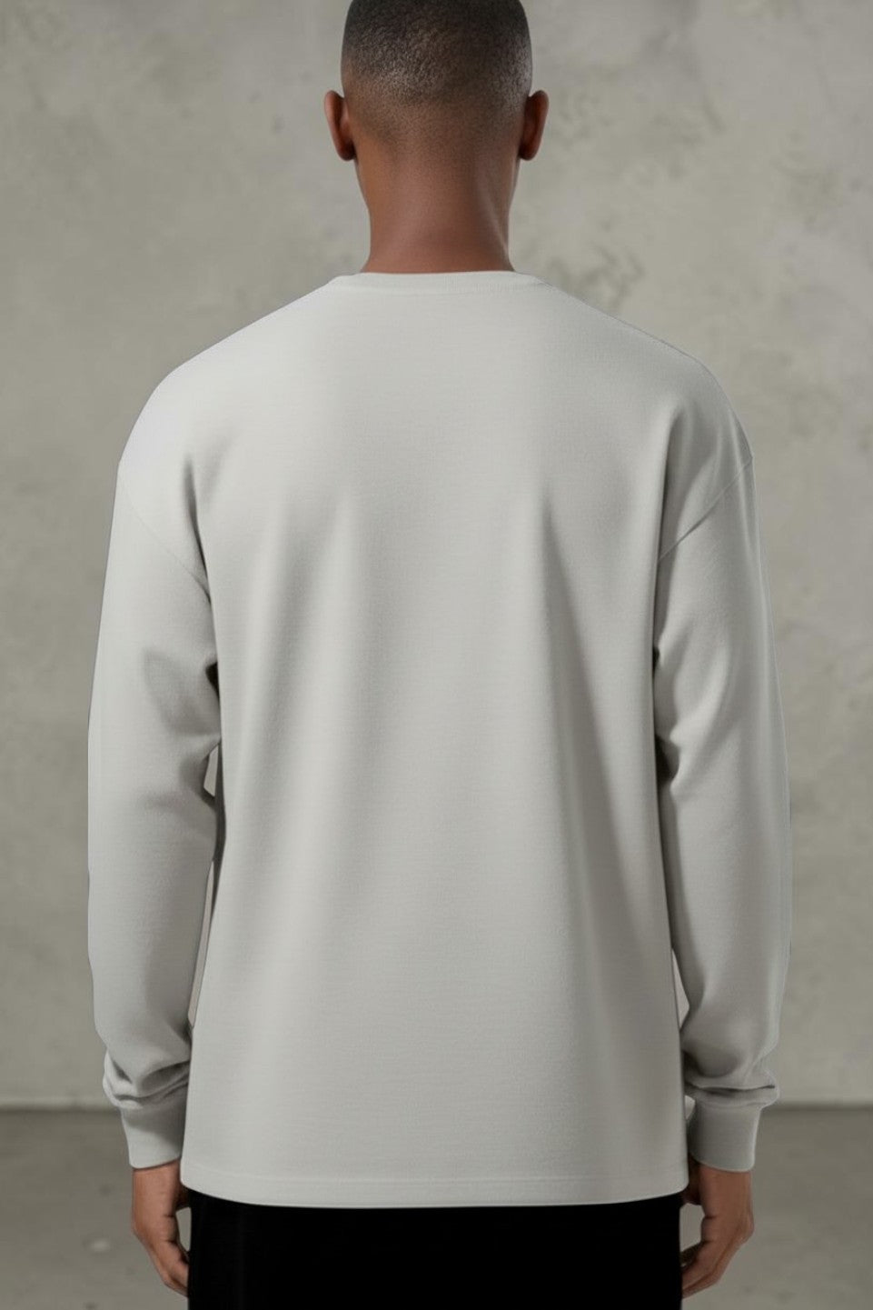 Back view of a man wearing a light grey SOLID APPRL long sleeve crewneck shirt with a relaxed fit and ribbed cuffs.