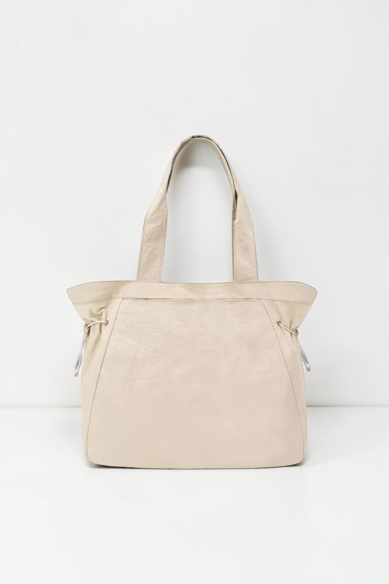 SOLID APPRL beige lightweight tote handbag with adjustable side cinches and comfortable shoulder straps.