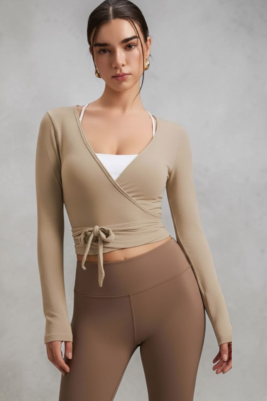 Model wearing a beige SOLID APPRL long sleeve wrap top with a tie front and V-neckline, paired with a brown skirt.