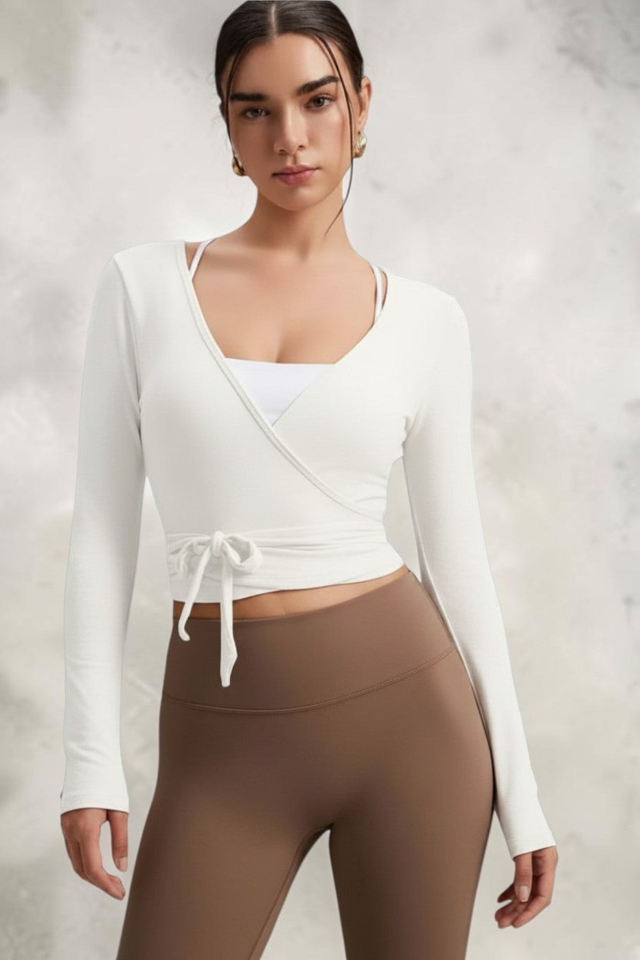 Model wearing a white SOLID APPRL long sleeve wrap top with a V-neck and tie-front waist, paired with a brown skirt.
