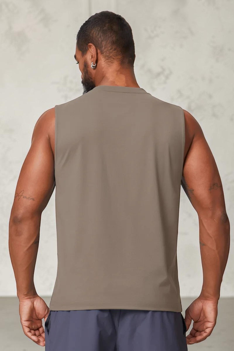 Back view of a man wearing a taupe SOLID APPRL performance sleeveless tank top with a crew neck and athletic fit.