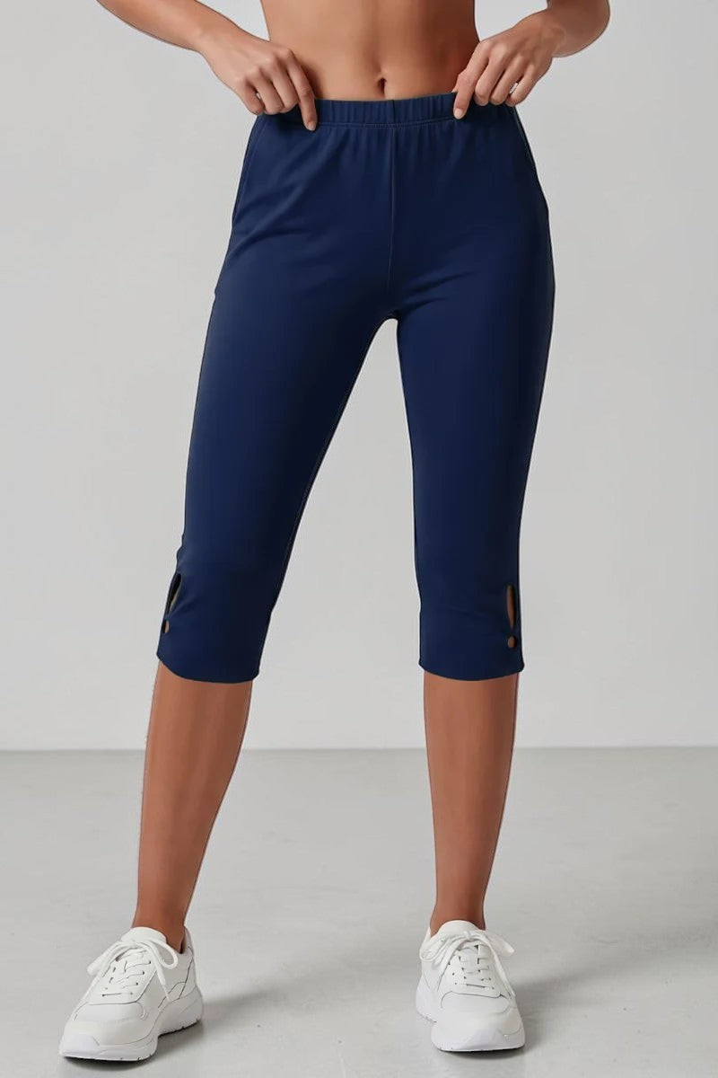 SOLID APPRL navy blue athletic capri leggings with high-rise waistband and stylish hem cutouts on a model.