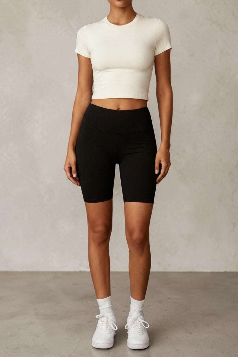 SOLID APPRL off-white short sleeve crew neck crop top in a soft, stretchy fabric worn with high-waisted denim jeans.