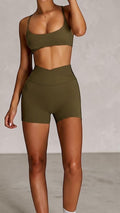 SOLID APPRL olive green high-waisted athletic shorts with crossover waistband and matching sports bra.