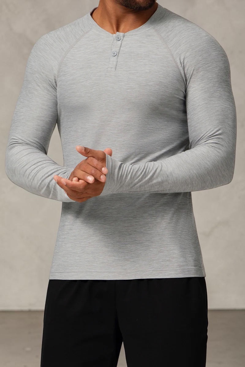 SOLID APPRL grey heathered long sleeve performance henley shirt with raglan sleeves and two-button placket on a model
