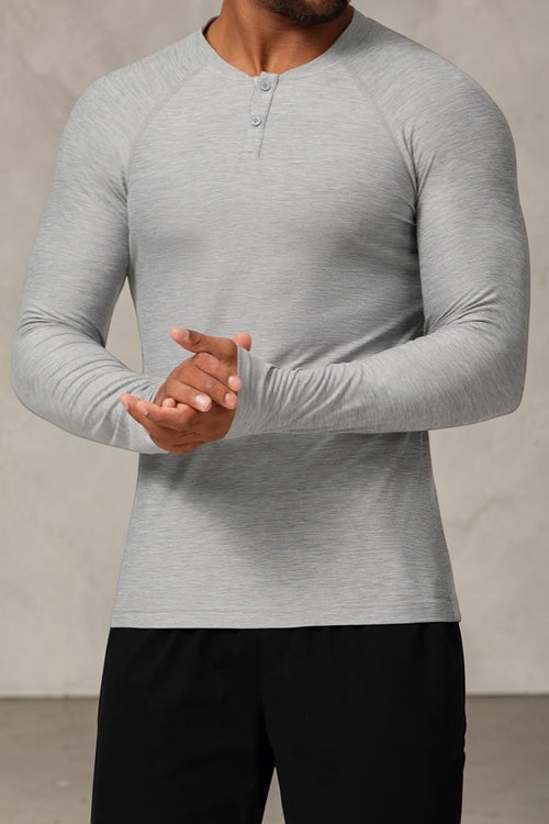 SOLID APPRL grey heathered long sleeve performance henley shirt with raglan sleeves and two-button placket on a model
