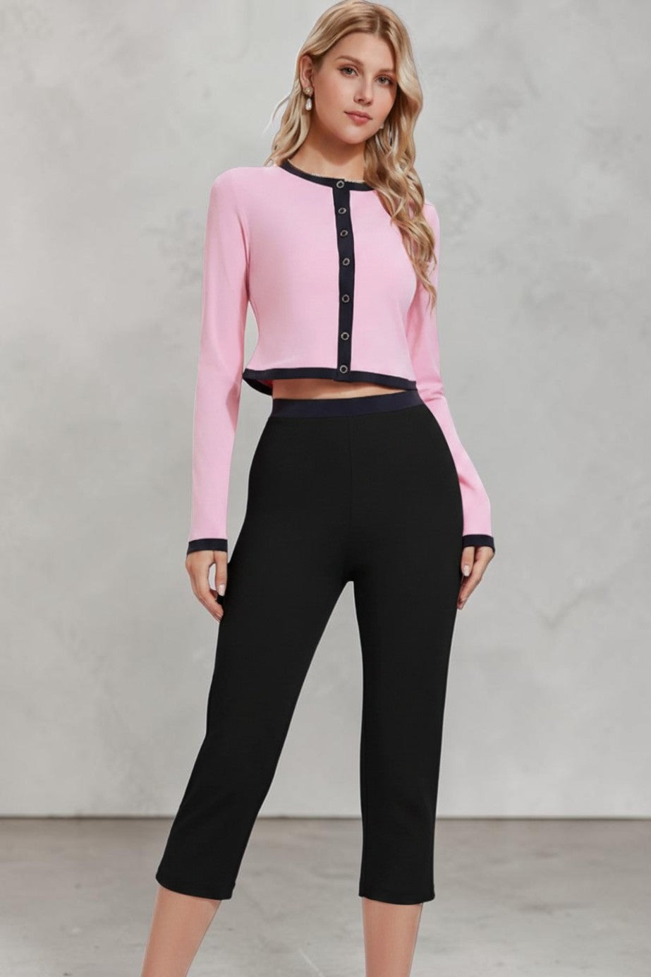 Model wearing a pink SOLID APPRL long sleeve button-up crop top with black contrast trim on a light background.