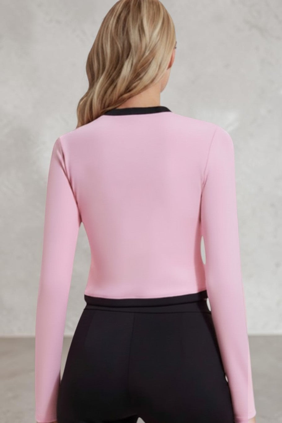 Model wearing a SOLID APPRL pink long sleeve crop top with black trim details against a plain white background.