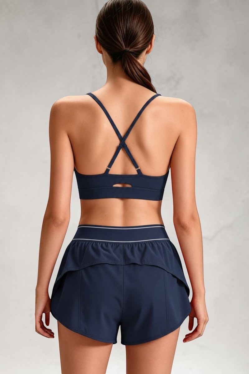 SOLID APPRL women's red athletic sports bra with cross-back straps and matching shorts with elastic waistband.