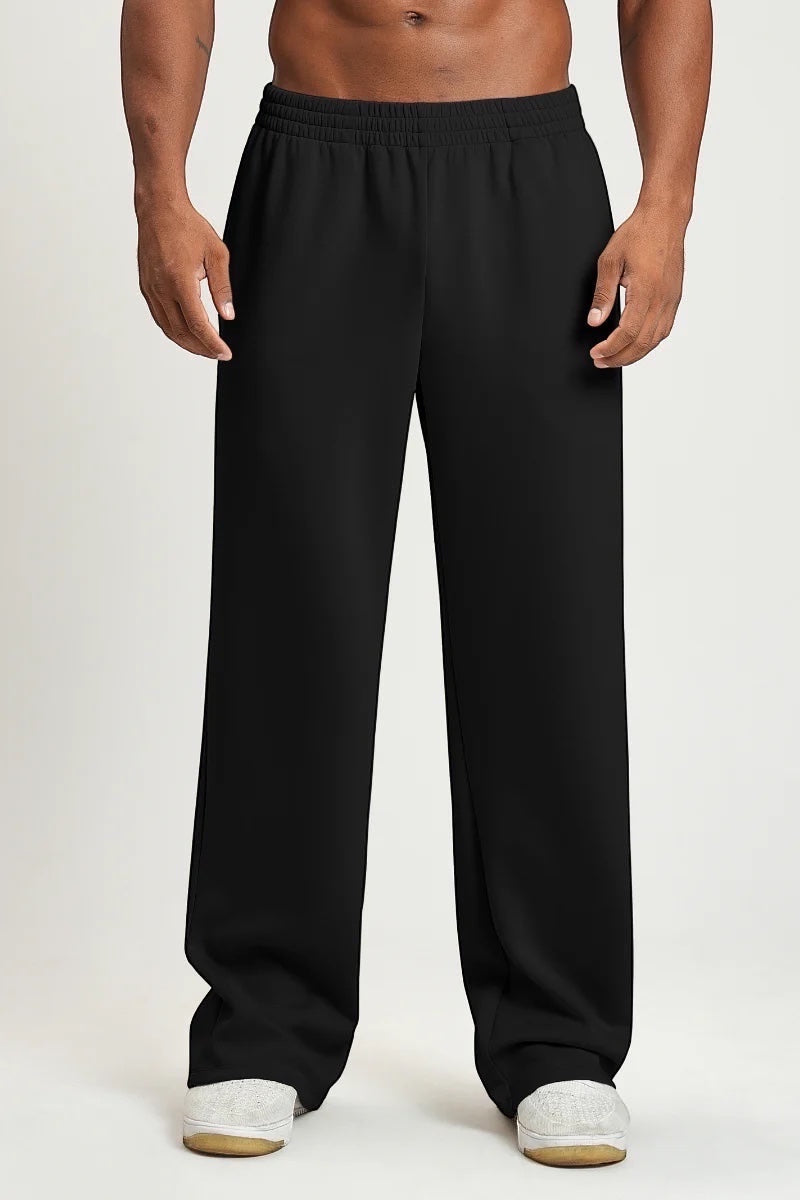 SOLID APPRL black relaxed-fit sweatpants with an elastic waistband worn by a shirtless man on a neutral background.