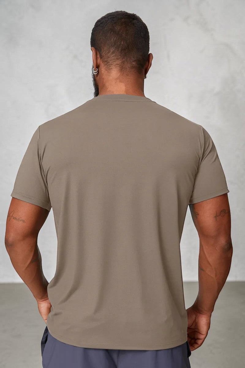 Back view of a man wearing a SOLID APPRL taupe performance crew neck t-shirt with an athletic fit.