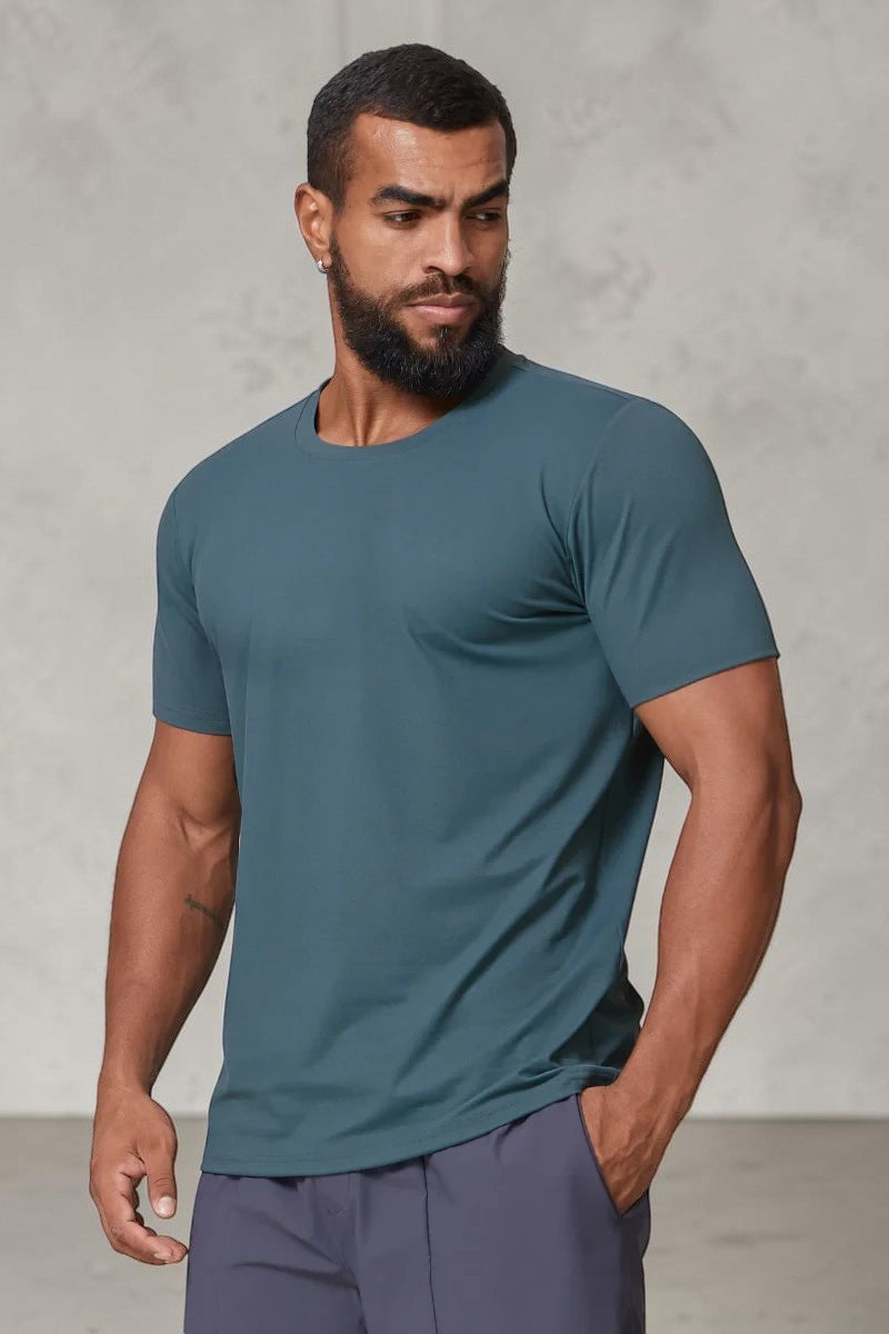 SOLID APPRL men's teal performance crew neck t-shirt with an athletic fit on a model against a light background.