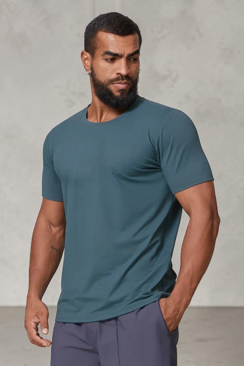 SOLID APPRL men's teal performance crew neck t-shirt with an athletic fit on a model against a light background.
