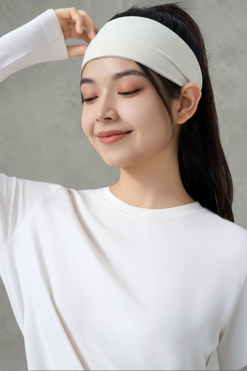 SOLID APPRL white moisture-wicking athletic headband worn by a woman in a matching long-sleeve workout shirt.
