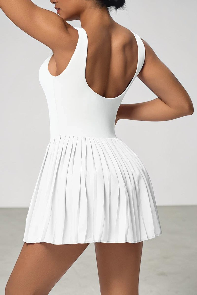 SOLID APPRL white pleated athletic tennis dress with a scoop back, worn by a model against a neutral background.